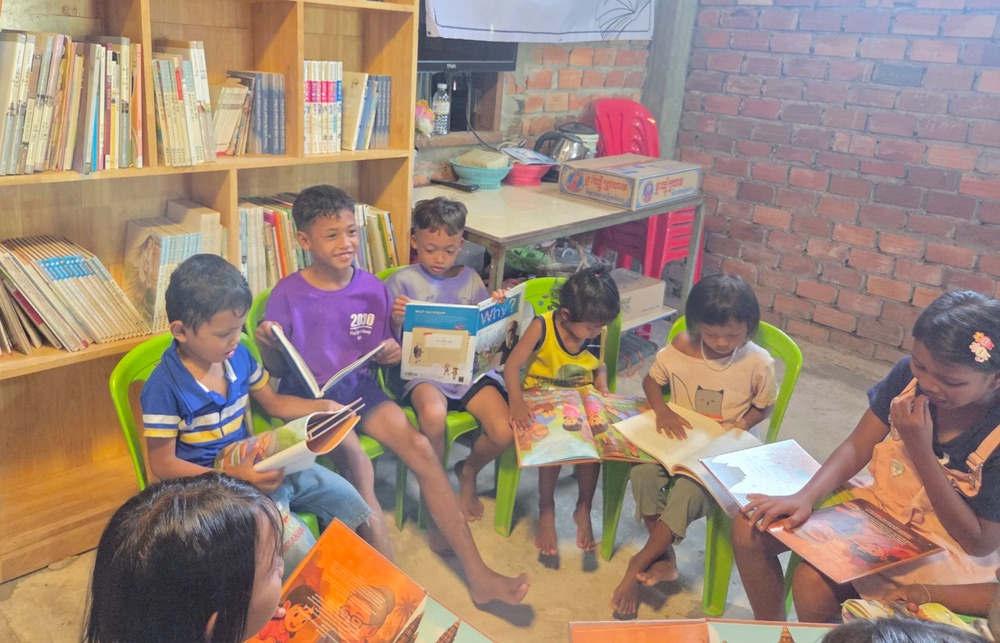 Children reading picture books in a Siem Reap library